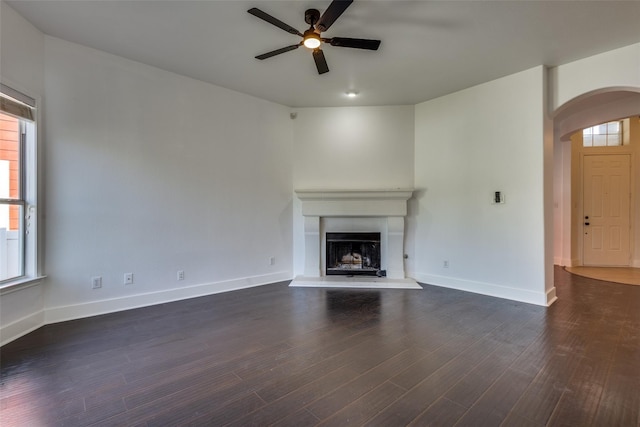 unfurnished living room featuring ceiling fan and dark hardwood / wood-style floors