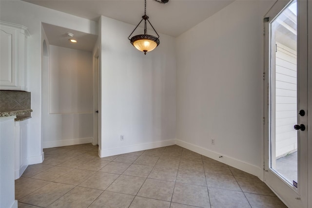 unfurnished dining area with light tile patterned flooring