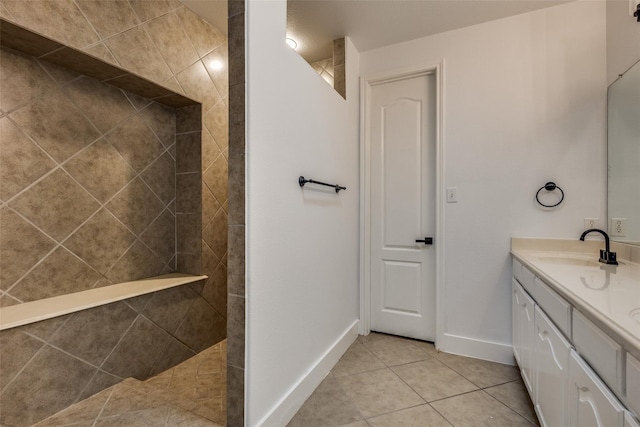 bathroom with tile patterned floors, vanity, and a tile shower