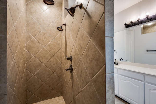 bathroom with a tile shower and vanity