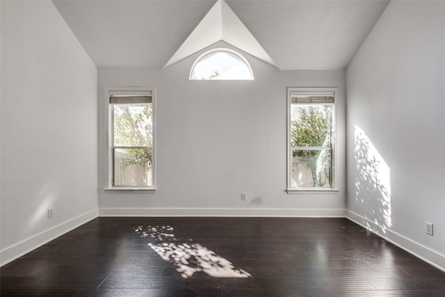 spare room featuring dark hardwood / wood-style floors and lofted ceiling