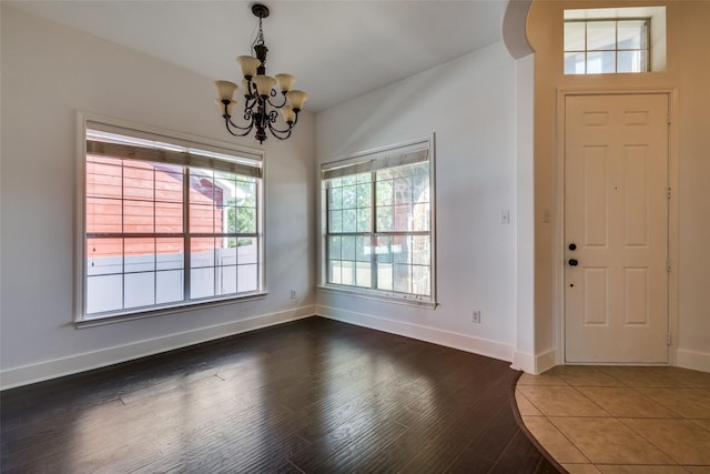 foyer with dark hardwood / wood-style floors and a notable chandelier