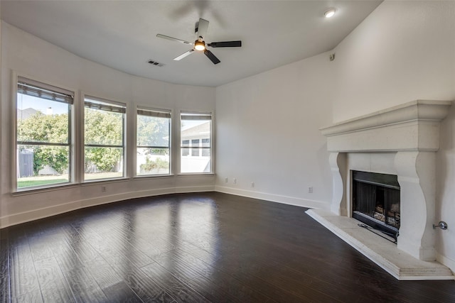 unfurnished living room with dark hardwood / wood-style floors, a wealth of natural light, and ceiling fan