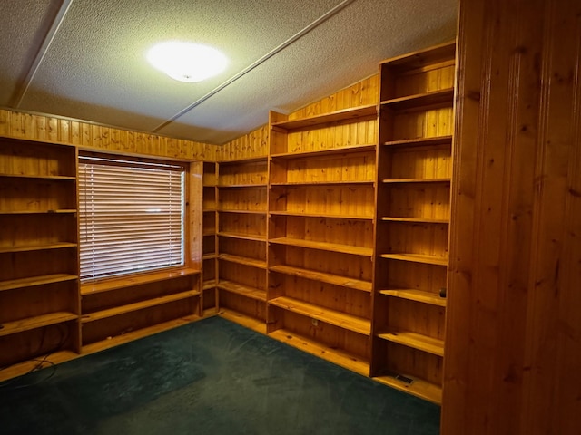 spacious closet with dark carpet and vaulted ceiling