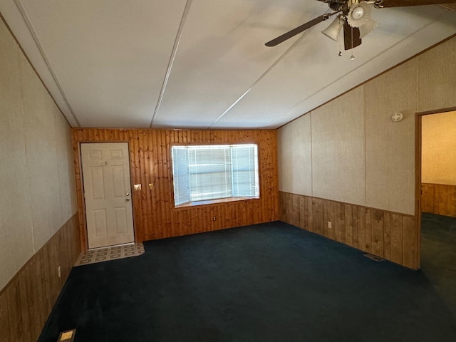 spare room featuring dark colored carpet and ceiling fan