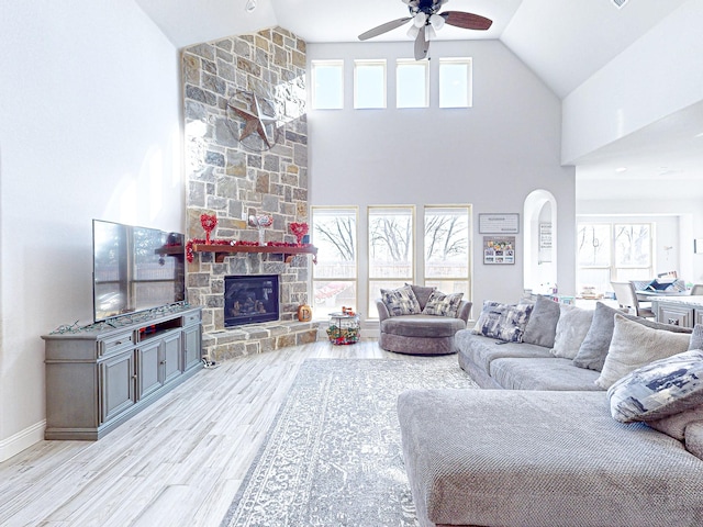 living room featuring ceiling fan, light wood-type flooring, high vaulted ceiling, and plenty of natural light