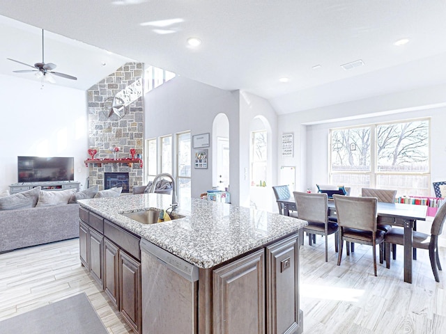 kitchen featuring vaulted ceiling, an island with sink, plenty of natural light, sink, and stainless steel dishwasher