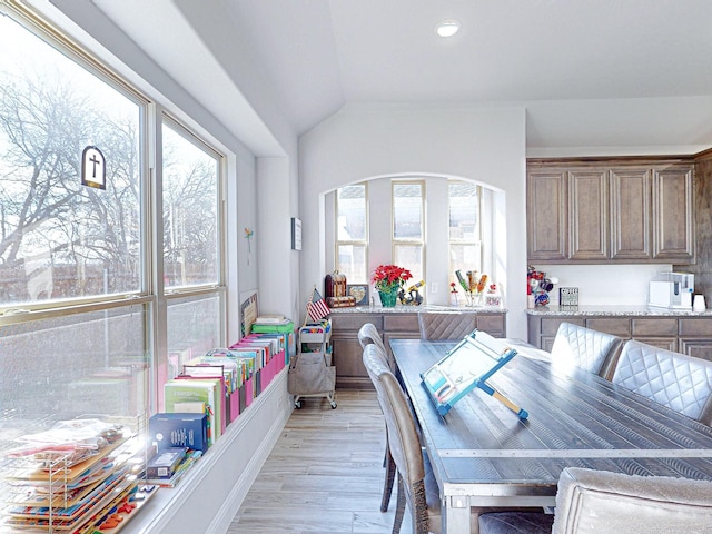 dining area with light hardwood / wood-style flooring and lofted ceiling