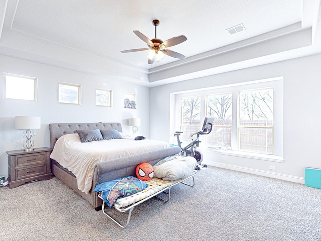 bedroom featuring ceiling fan, light colored carpet, and a raised ceiling