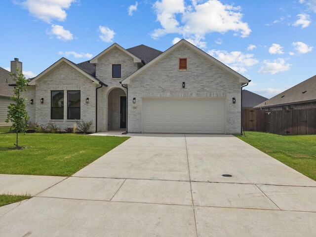 220 Magnolia Dr, Azle, TX 76020 - french provincial home featuring concrete driveway, brick siding, and a garage