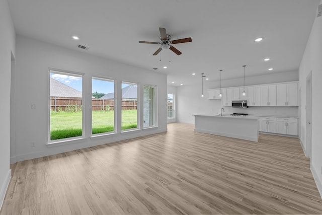 220 Magnolia Dr, Azle, TX 76020 - unfurnished living room with a sink, recessed lighting, light wood-style floors, a ceiling fan, and baseboards