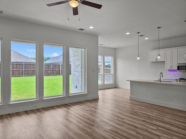 220 Magnolia Dr, Azle, TX 76020 - kitchen featuring a sink, stainless steel microwave, wood finished floors, recessed lighting, and stove
