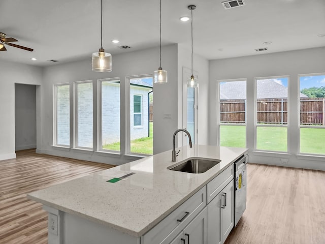 220 Magnolia Dr, Azle, TX 76020 - kitchen featuring a sink, light wood-style floors, open floor plan, a ceiling fan, and decorative light fixtures