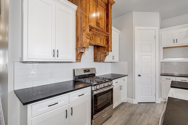 kitchen with light hardwood / wood-style flooring, white cabinetry, and stainless steel gas range oven