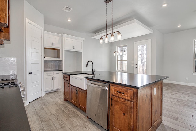 kitchen with white cabinets, a center island with sink, stainless steel dishwasher, and sink