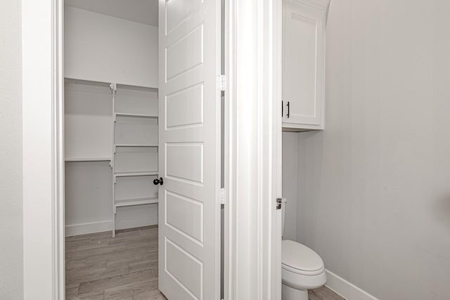 bathroom featuring hardwood / wood-style floors and toilet