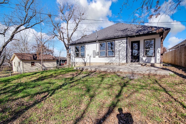 rear view of house featuring a lawn and a patio