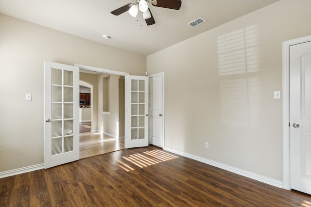 spare room featuring dark hardwood / wood-style floors, ceiling fan, and french doors