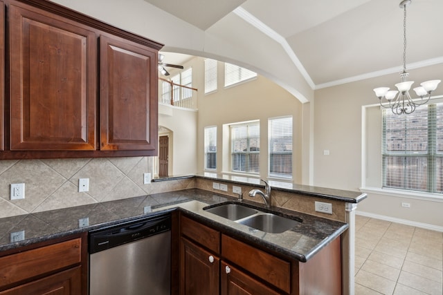 kitchen with sink, stainless steel dishwasher, dark stone counters, lofted ceiling, and ceiling fan with notable chandelier