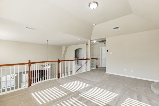 unfurnished room with light carpet and vaulted ceiling