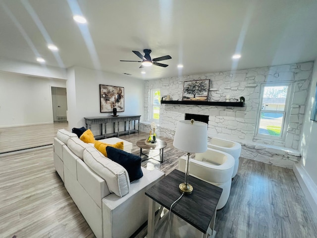 living room with ceiling fan and light hardwood / wood-style flooring