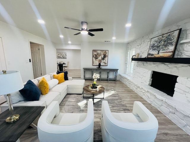 living room with ceiling fan, a fireplace, and hardwood / wood-style floors