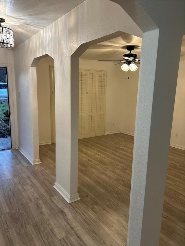 unfurnished room featuring hardwood / wood-style floors and ceiling fan with notable chandelier