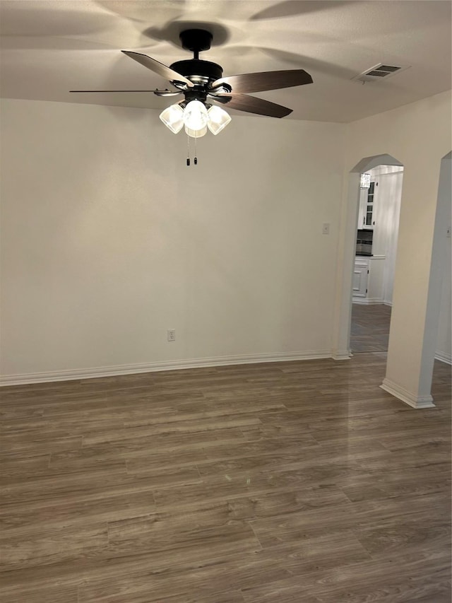 empty room with dark hardwood / wood-style flooring and ceiling fan