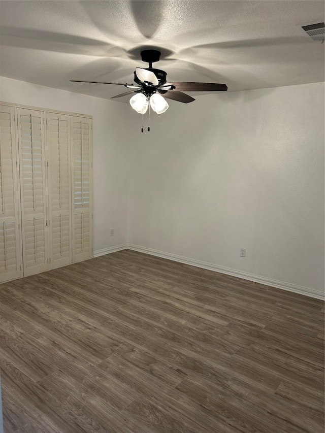 unfurnished bedroom featuring ceiling fan and dark wood-type flooring