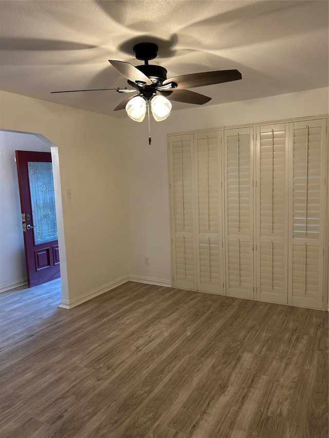 unfurnished bedroom with ceiling fan and wood-type flooring