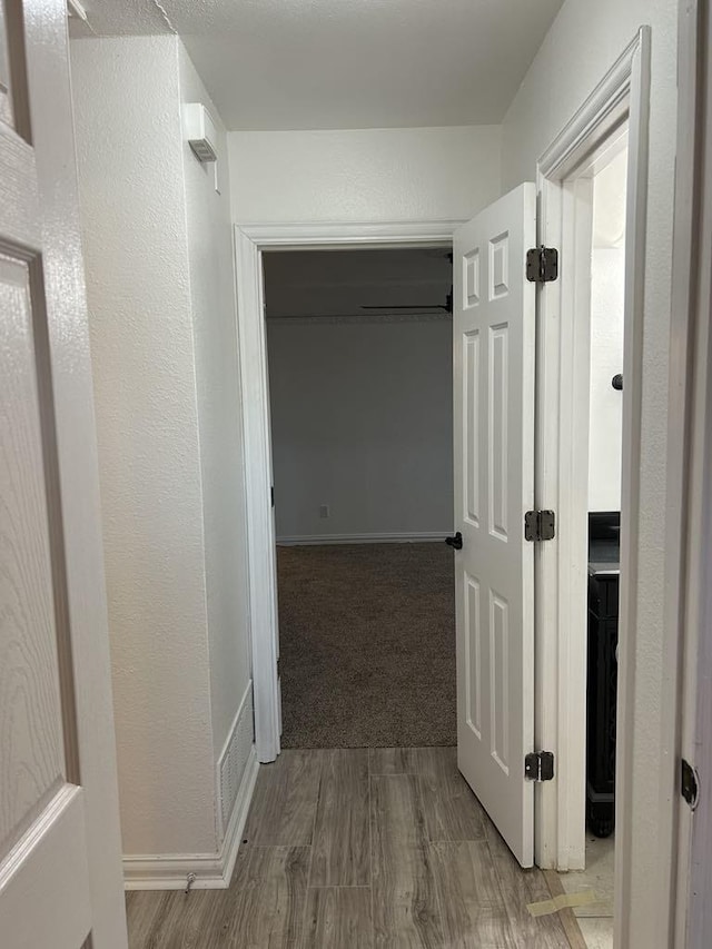 hallway with hardwood / wood-style floors