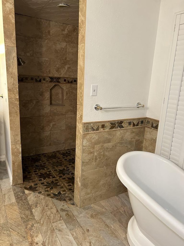 bathroom featuring tile walls and shower with separate bathtub