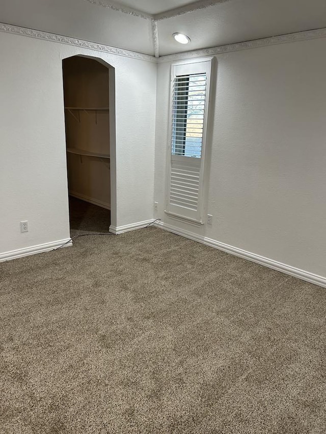 carpeted spare room with crown molding