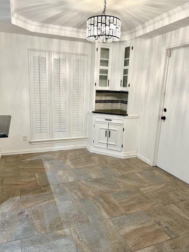 unfurnished dining area with an inviting chandelier and ornamental molding