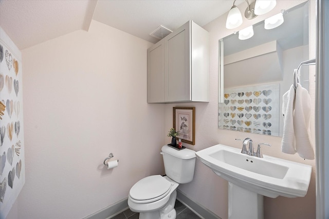 bathroom featuring sink, tile patterned floors, a textured ceiling, vaulted ceiling, and toilet