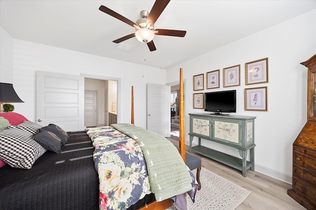 bedroom with ensuite bathroom, ceiling fan, and light wood-type flooring