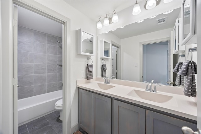 full bathroom with vanity, tiled shower / bath combo, and toilet