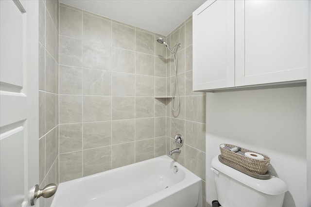 bathroom featuring tiled shower / bath combo and toilet