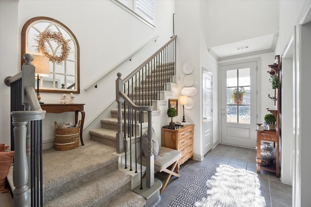 entrance foyer with a high ceiling and dark tile patterned flooring