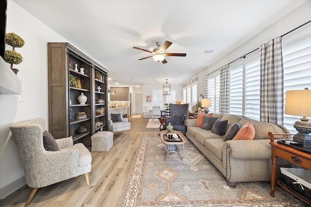 living room with ceiling fan and light hardwood / wood-style floors