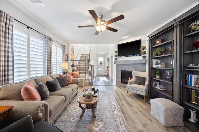 living room with a healthy amount of sunlight, ceiling fan, and light hardwood / wood-style floors