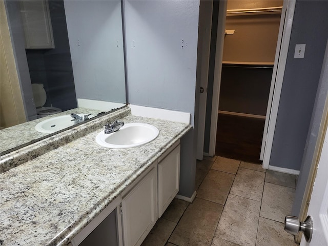 bathroom featuring tile patterned flooring, vanity, and toilet