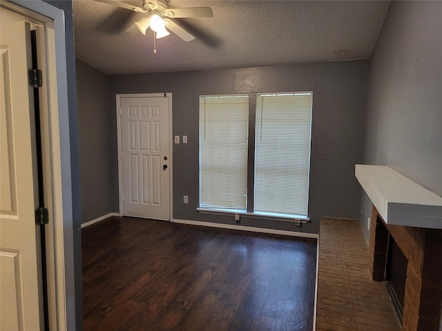 entryway with ceiling fan, dark hardwood / wood-style floors, and a textured ceiling