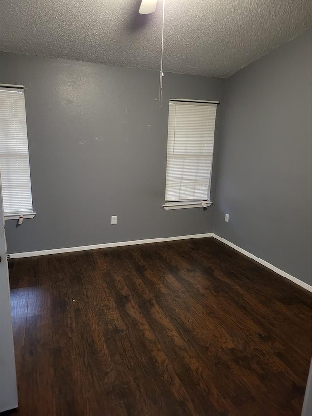 empty room with a textured ceiling, ceiling fan, and dark wood-type flooring