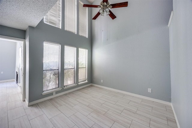 empty room with a textured ceiling and ceiling fan