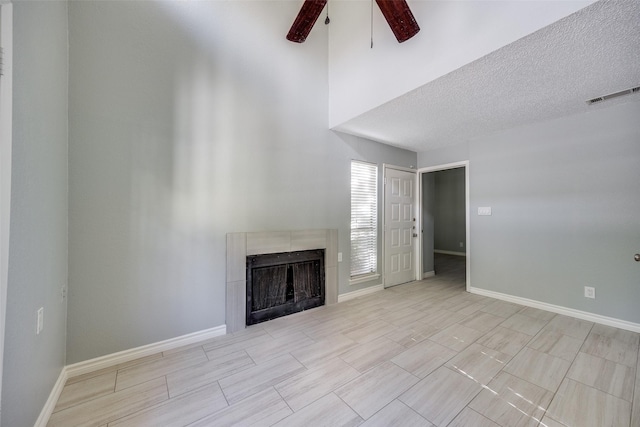 unfurnished living room with ceiling fan and a textured ceiling