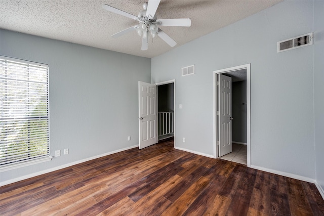 unfurnished bedroom with ceiling fan, dark hardwood / wood-style flooring, and a textured ceiling