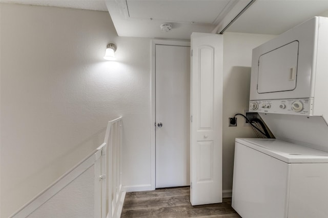 laundry room featuring stacked washer / drying machine and hardwood / wood-style flooring