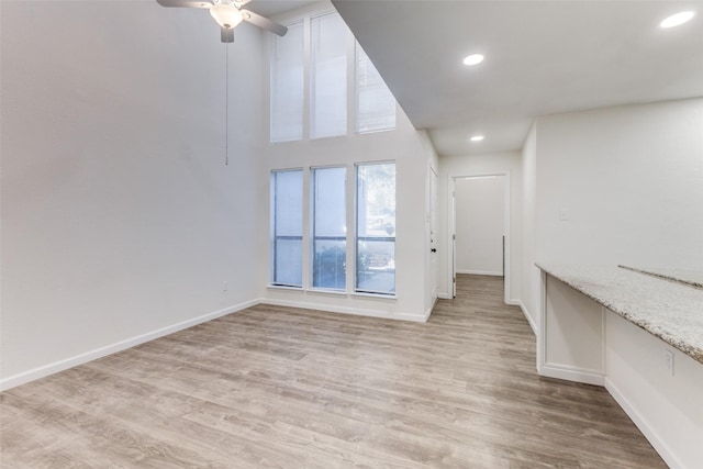 unfurnished living room with ceiling fan and light wood-type flooring