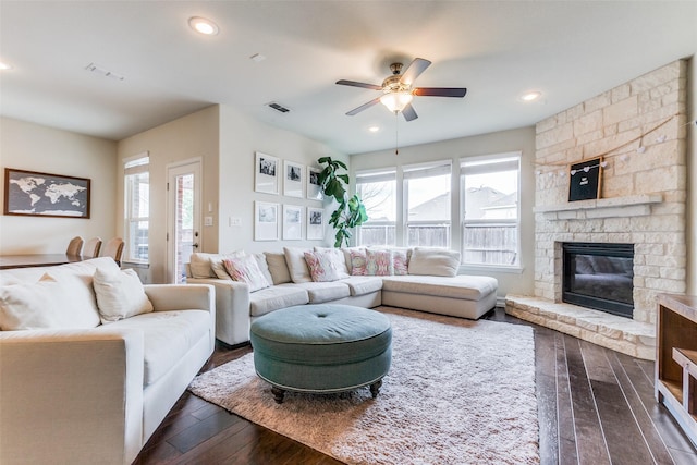 living room featuring dark hardwood / wood-style floors, ceiling fan, and a fireplace